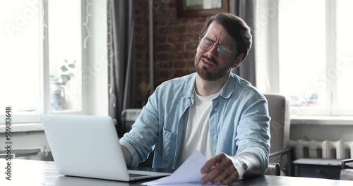 Wallpaper Mural Annoyed millennial man in glasses manage financial documents at home office read reports feel angry upset surprised with bad news failing sales. Distressed young businessman receive tax penalty paper Torontodigital.ca
