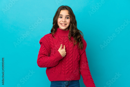 Little caucasian girl isolated on blue background with surprise facial expression