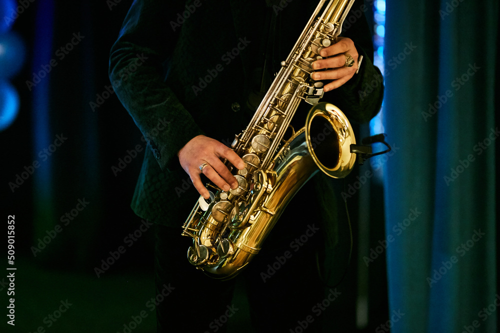 a man plays the saxophone, close-up of the hands. World Jazz Festival. Saxophone, a musical instrument played by a musician saxophonist in a festival. - obrazy, fototapety, plakaty 