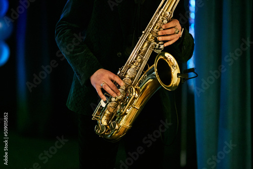 a man plays the saxophone, close-up of the hands. World Jazz Festival. Saxophone, a musical instrument played by a musician saxophonist in a festival. photo