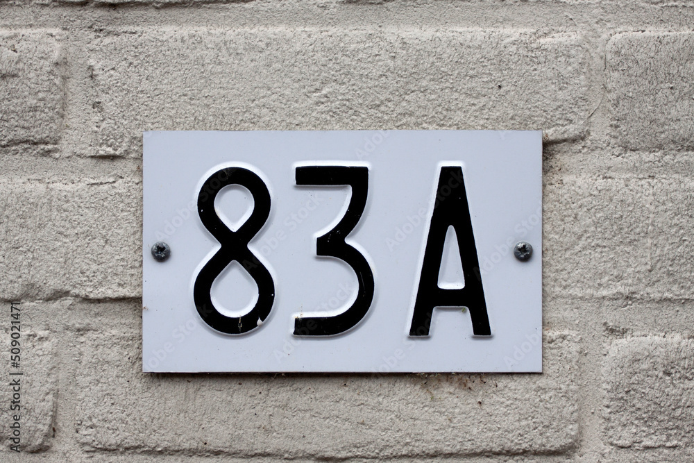 House number 83 sign on a brick wall House number 83 sign on a brick wall