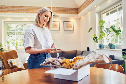 Mid adult woman preparing return of online order photo