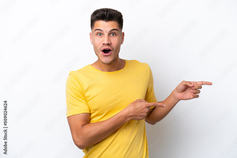 Young caucasian man isolated on white background surprised and pointing side Young caucasian man isolated on white background surprised and pointing side