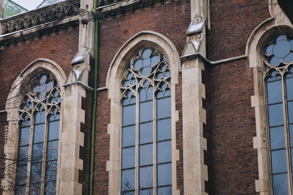Obraz premium Three old pointed gothic windows with stained glass on facade of the building. Baroque and Gothic architecture. Church of St. Olga and Elizabeth. Lviv, Ukraine.