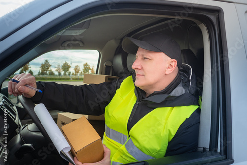 Delivery service employee. Courier driving car. Delivery service worker is driving. Work in courier business. Career in logistics company. Logistic - courier service. Transportation of goods