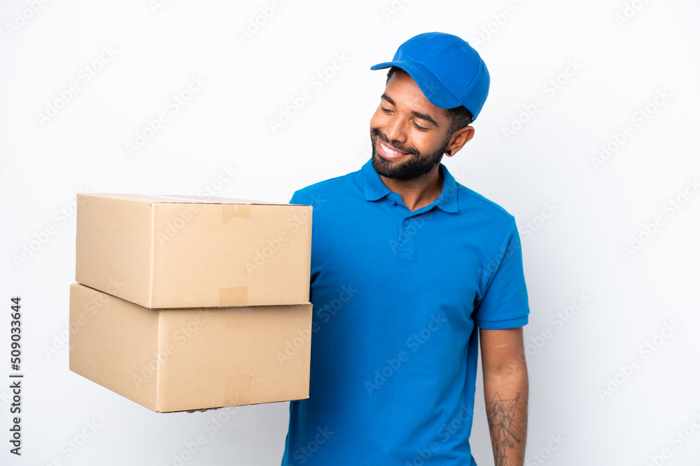 Delivery Brazilian man isolated on white background looking to the side and smiling Delivery Brazilian man isolated on white background looking to the side and smiling