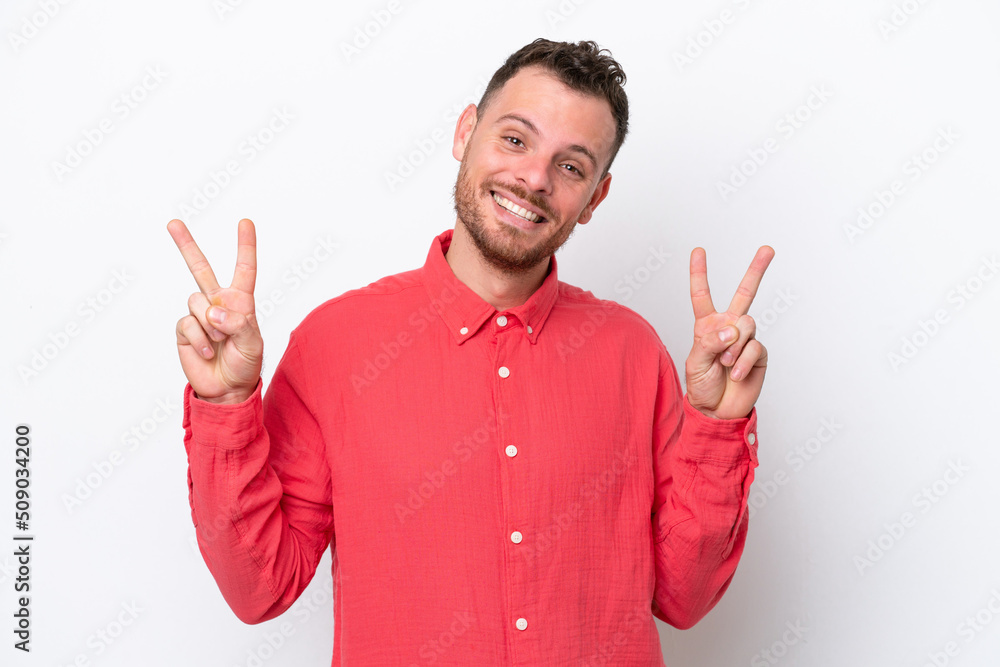 Young Brazilian man isolated on white background showing victory sign with both hands Young Brazilian man isolated on white background showing victory sign with both hands