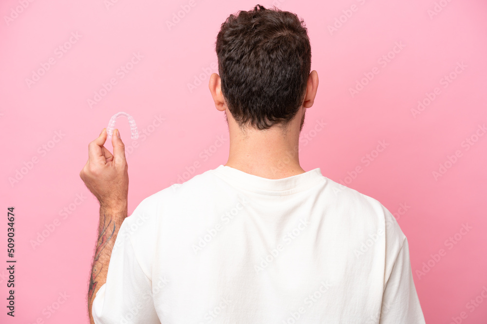 Brazilian man holding invisible braces in back position Brazilian man holding invisible braces in back position