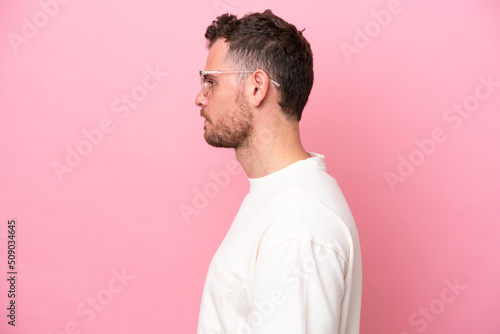 Young brazilian man isolated on pink background With glasses