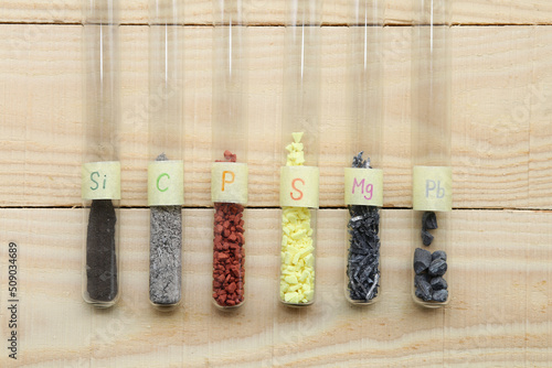 Chemical elements, simple substances non-metals and metals in test tubes: amorphous silicon, gray carbon, crystalline red phosphorus, yellow crystalline sulfur, magnesium, heavy lead. photo