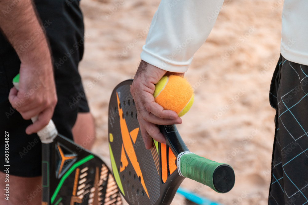 Obraz premium Beach tennis rackets and balls on the beach sand