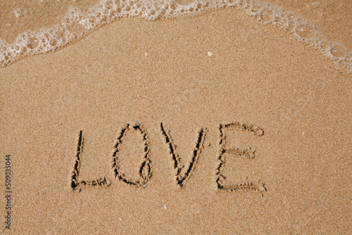 Love - handwritten on the soft beach sand. © De Visu
