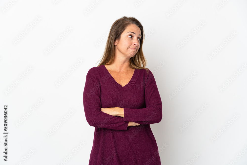 Middle age Brazilian woman isolated on white background having doubts while looking side Middle age Brazilian woman isolated on white background having doubts while looking side