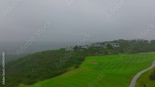 Forwards fly above golf course and luxury buildings surrounded by shrubs and green vegetation. Port Elisabeth, South Africa