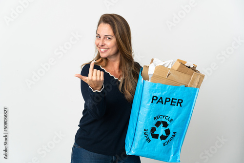 Middle age Brazilian woman holding a recycling bag full of paper to recycle over isolated background doing coming gesture