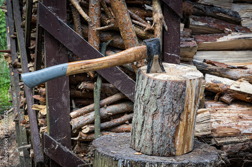 An axe driven into a stump. Preparing firewood. Chopping wood on a stump.