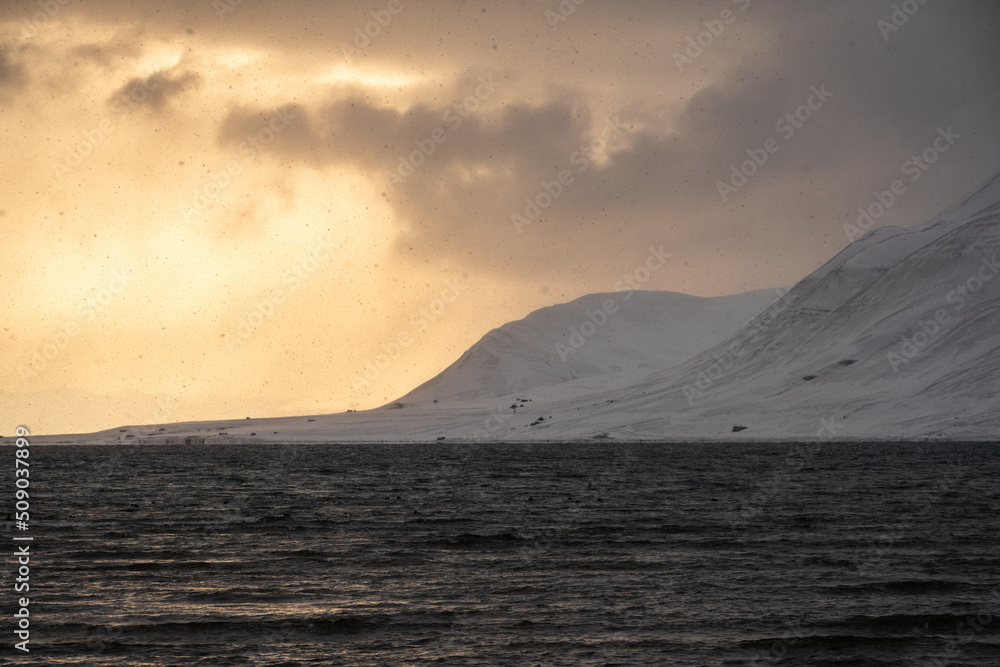 Panoramic view in golden hour of the mountains, snow and Sea in Svalbard, Norway Panoramic view in golden hour of the mountains, snow and Sea in Svalbard, Norway