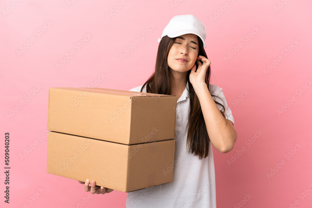 Delivery girl over isolated pink wall frustrated and covering ears Delivery girl over isolated pink wall frustrated and covering ears