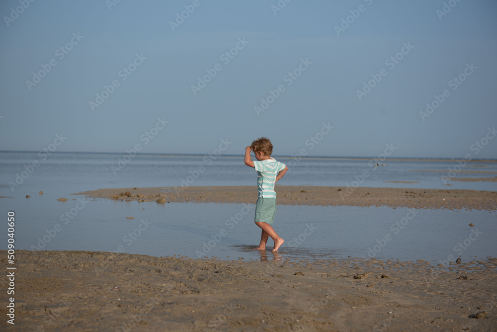 A boy is playing on the beach