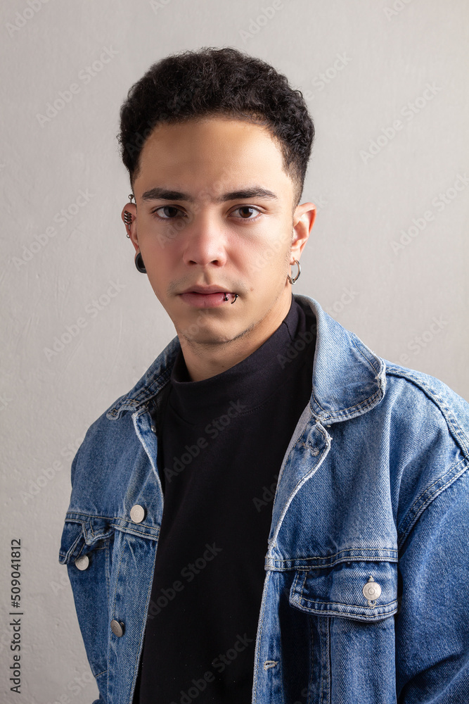 Obraz premium Model Young man with curly hair and confident pose wearing a denim jacket