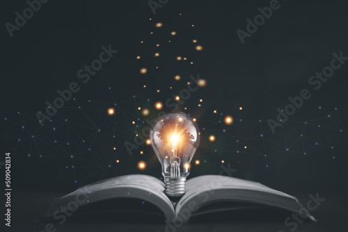 Obraz na płótnie Glowing light bulb on a book, Inspiring from read concept, Educational knowledge and business education ideas, Innovations, self-learning, knowledge and searching for new ideas