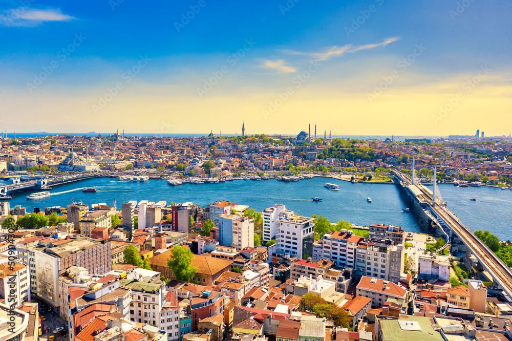 Touristic sightseeing ships in Golden Horn bay of Istanbul and view on Suleymaniye mosque with Halic bridge against blue sky. Istanbul, Turkey during sunny summer day.