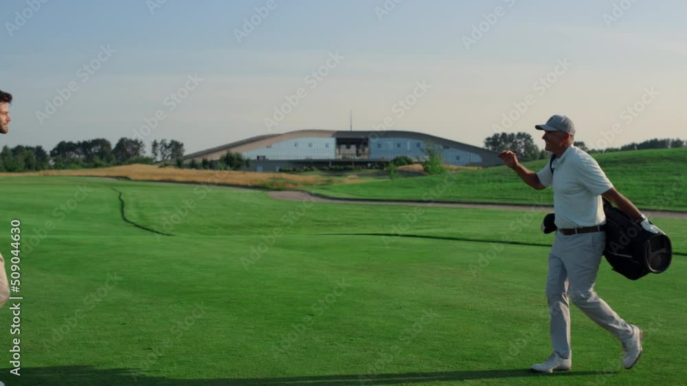 Golf players shaking hands on grass field. Two friends meeting play on weekend. Golf players shaking hands on grass field. Two friends meeting play on weekend.