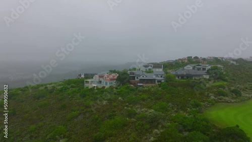 Slide and pan footage of residential borough surrounded by nature. Large and luxurious houses in misty landscape. Port Elisabeth, South Africa