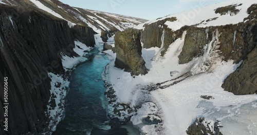 River flowing through Snowy Studlagil Canyon in Iceland - Aerial photo