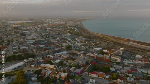 Fly above town at dusk. Aerial descending footage of development along sea coast. Port Elisabeth, South Africa