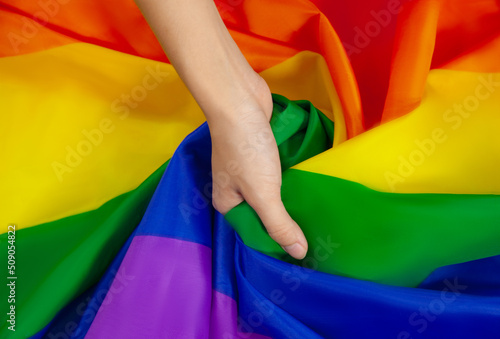 Flag of pride. LGBTQ flag and hand a symbol of Lesbian Gay Bi sexsual Transgender Queer or homosexsual pride Rainbow flag. black background. Represent hand symbol of freedom equality. photo
