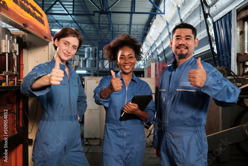 Fotografía Cheerful multiracial industry workers in safety uniforms line up and thumb up together after work success and express smiles and happiness in mechanical factory