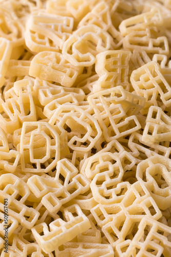 closeup macro view of pasta letters or alphabet, full frame background, diet and food concept, taken in shallow depth of field