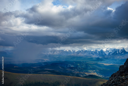 Majestic mountain landscape opening from a viewing point. Panorama of mountain peaks and stormy sky.