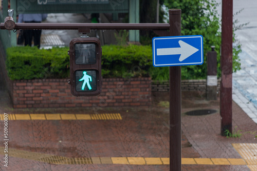 雨の日に横断歩道の歩行者信号機の風景