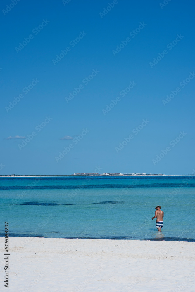 Rear view of man in swimsuit at sea looking at the horizon and blue sky