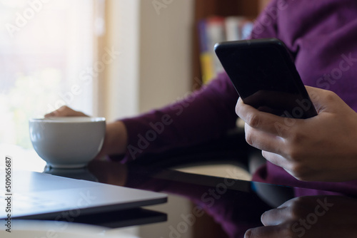 Person use mobile phone while drinking coffe  photo