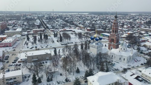 Scenic view from drone of temple complex of Cathedral of Archangel Michael and Church of Jerusalem Icon of Mother of God with Bronnitsy cityscape on background in winter, Russia