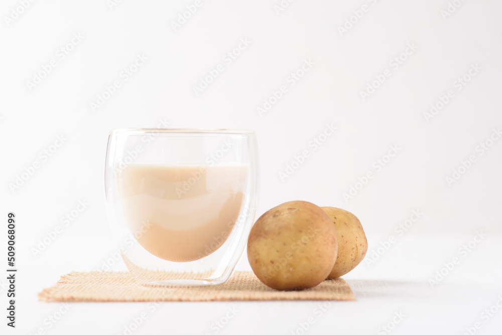 Potato milk in a glass, a healthy plant based drink on white background Potato milk in a glass, a healthy plant based drink on white background