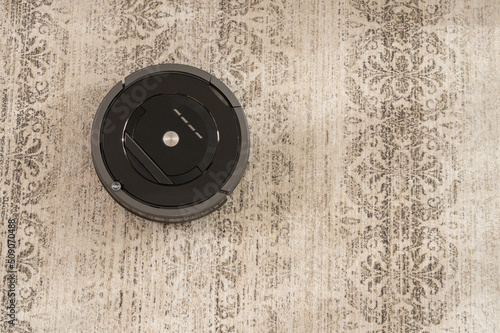 robot vacuum cleaner on carpet top view black color