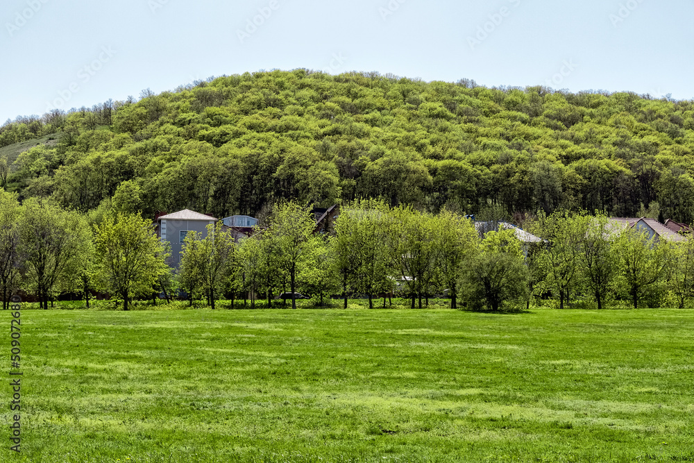 A small settlement on a hillside in the spring season on a sunny day. A small settlement on a hillside in the spring season on a sunny day.
