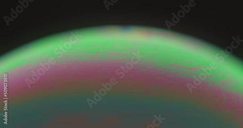 Macroscopic view of soap bubble showing colorful and bright layers. Close up.