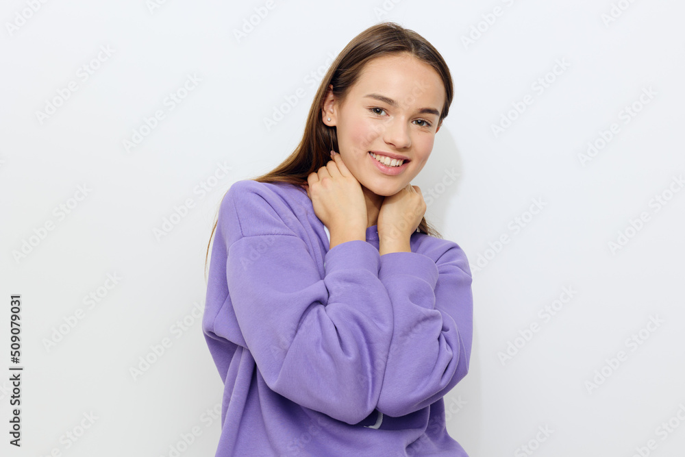 a beautiful woman stands on a white background in a purple tracksuit joyfully presses her hands to her neck, slightly hunched over a beautiful woman stands on a white background in a purple tracksuit joyfully presses her hands to her neck, slightly hunched over