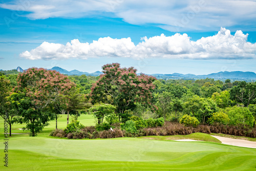 Beautiful green view at golf course ,green trees and mountain blue sky white cloud background