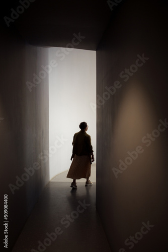 back silhouette of woman coming out of dark into light. concept of freedom  improvements  mental health  exit.