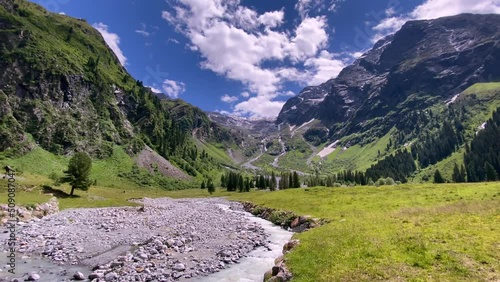 River with stones in the beautiful Lüsens valley in Austria with high mountains and blue sky in the background photo