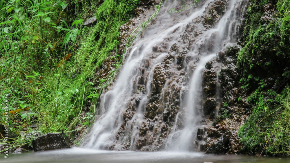 Beautiful waterfall in tropical green tree forest. Waterfall is flowing in jungle. Nature abstract background. Granite rock mountain Beautiful waterfall in tropical green tree forest. Waterfall is flowing in jungle. Nature abstract background. Granite rock mountain