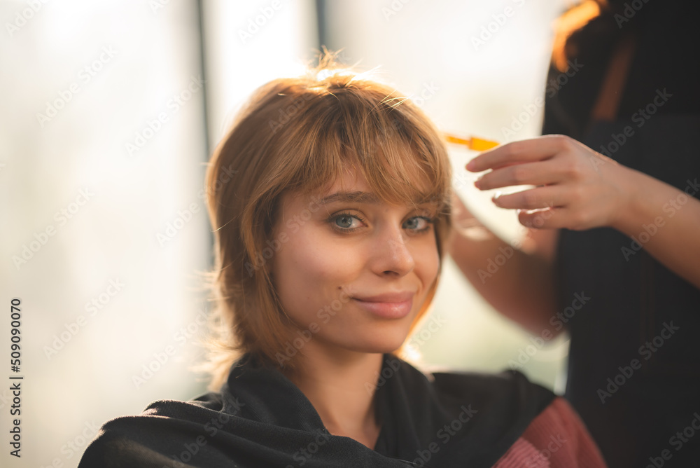 Fototapeta premium concept of professional fashion hairdresser and hair beauty salon, hairstylist making treatment to woman client person, by using scissors for haircut and coiffure care, girl style in studio lifestyle
