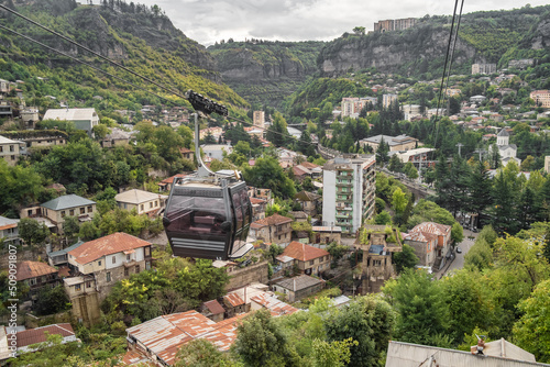 Cable car passing by old soviet era buildings in Chiatura miners city in Georgia photo
