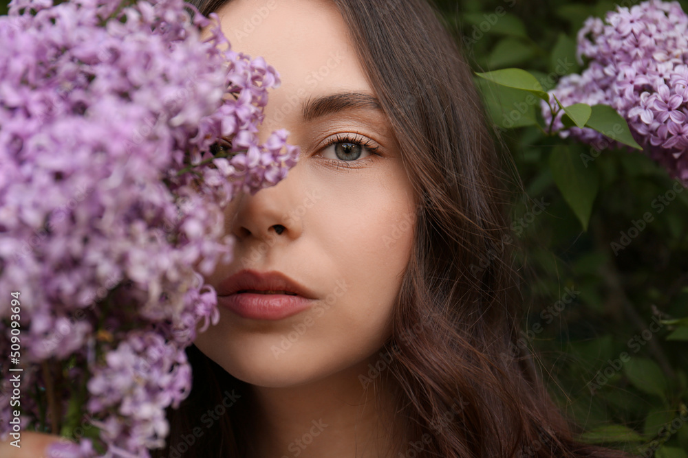 Attractive young woman near blooming lilac bush outdoors, closeup Attractive young woman near blooming lilac bush outdoors, closeup